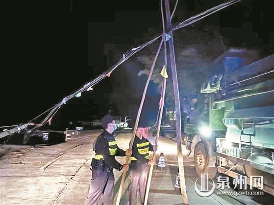 光纜線(xiàn)掉落導(dǎo)致路面交通堵塞 民警頂著寒風(fēng)用竹竿撐起